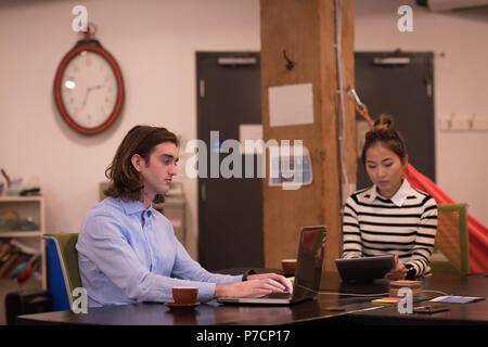 Geschäftskollegen mit Laptop und digital-Tablette am Schreibtisch Stockfoto