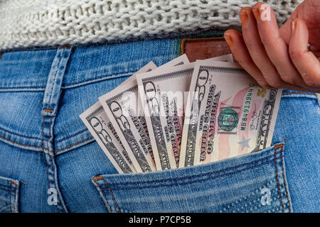 Weibliche Hand erreichen für 50 US-Dollar Scheine in ihre Jeans Gesäßtasche Stockfoto