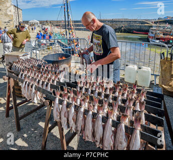 PORTSOY FESTIVAL ABERDEENSHIRE SCHOTTLAND Arbroath Smokies Schellfisch Fisch zubereitet auf Regalen VOR DEM RAUCHEN UND EIN FEUER MIT FLAMMEN IM FASS Stockfoto