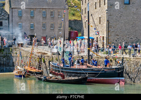 PORTSOY FESTIVAL ABERDEENSHIRE SCHOTTLAND Arbroath Smokies SCHELLFISCH FISCH RAUCH AUS FÄSSERN VON FISCH UND DAS SCHIFF ISABELLA FORTUNA gegen die HAFENMAUER Stockfoto