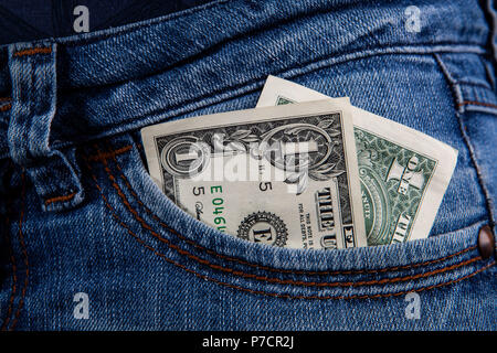 1 US-Dollar Bill in der Tasche auf der Vorderseite der weiblichen Blue Jeans - Mindestlohn Konzept Stockfoto