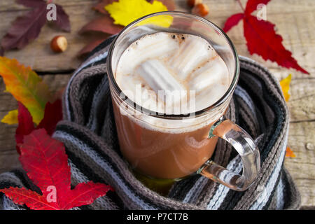 Heißer Kakao Marshmallow auf einen gestrickten Wollschal. Wärmendes Getränk für den Herbst Stockfoto