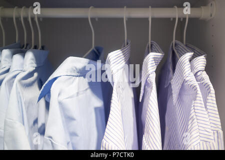 Business gestreift und glatte Hemden hängen in einem Schrank Stockfoto