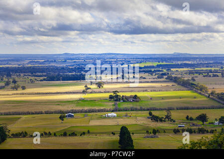 Ländliche Landschaft in Australien - grüne Felder und Hügel bei bewölktem Himmel Stockfoto