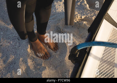 Männliche surfer stehend mit Drachen am Strand Stockfoto