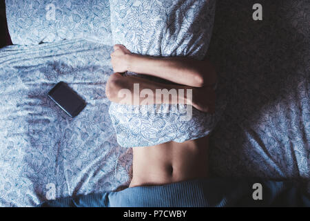 Frau umarmt Kissen beim schlafen im Schlafzimmer Stockfoto