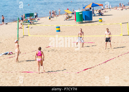 Gruppe von Menschen, Männer und Frauen spielen Beachvolleyball Stockfoto