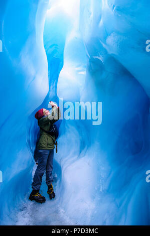 Frau fotografieren in einer Eishöhle in Fox Glacier, South Island, Neuseeland Stockfoto