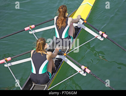 Zwei junge Frauen rudern Rennen in See Stockfoto