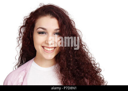 Happy teenage Mädchen mit langen Locken und toothy Lächeln isoliert auf weißem Stockfoto
