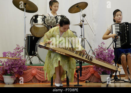 Junge Koreanische Schule führen Kinder für Touristen auf ihre Schule in Pyongyang, Nordkorea mit einem kayagum Solist.. Stockfoto