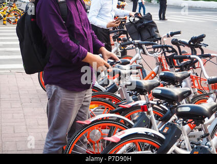 Peking, China - September 2017: Männer mit Smartphones den QR-Code zu scannen und entsperren Sie ein Fahrrad vom Fahrrad teilen Unternehmen Mobike Stockfoto