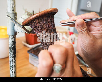 Frau kleben kleine geformte cloisonne Drähte mit einem Kupfer vase eine aufwendig konstruierte Muster für eine Email cloisonne Vase, Peking, China Stockfoto