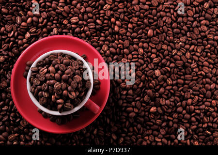 Rote Kaffeetasse mit gerösteten Bohnen gefüllt Stockfoto