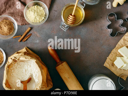 Flach Weihnachten Lebensmittel Konzept. Rahmen der Rohstoffe für das Kochen gingerbread man Cookies in Weihnachten auf dunklem Hintergrund Mehl, Zucker, Butter, Ho Stockfoto