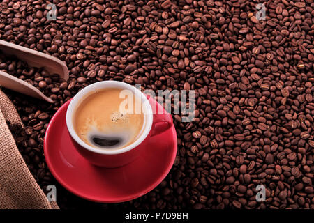 Rote Kaffeetasse mit Espresso und gerösteten Bohnen Stockfoto