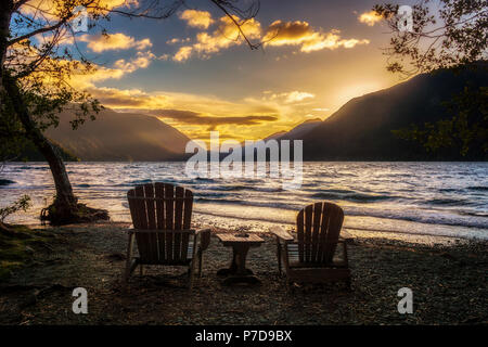 Sonnenuntergang über Lake Crescent mit zwei Stühle aus Holz am Ufer, Olympic National Park, Washington State, USA. Stockfoto