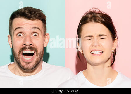 Closeup Portrait von junges Paar, Mann, Frau. Eine glücklich lächelnde aufgeregt wird, andere schwere, besorgt auf Rosa und blauen Hintergrund unglücklich. Emotion Kontraste Stockfoto