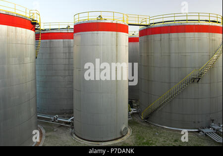 Big Oil Tanks mit ihren Treppen und Rohre im Morgenlicht Stockfoto