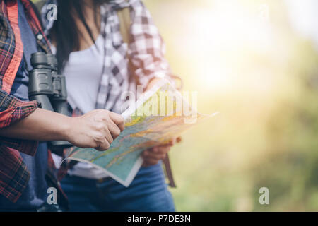Seitenansicht des jungen Paares ist angenehm Karte halten und es mit Konzentration während der Ferien, Wandern Konzept. Stockfoto