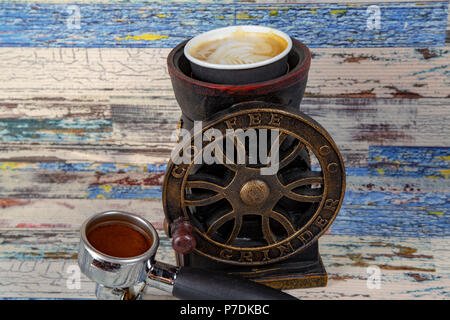 Kaffeemaschine bereitet frischen Kaffee. Nahaufnahme der Filterhalter mit Boden Puder auf Bar Kaffeemaschine. und Gießen in weißen Schale an. Stockfoto