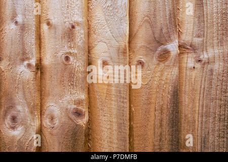 Brauner Holzfedertafel- oder Closeboard-Zaun mit verknoteten Planken. Rustikaler strukturierter Hintergrund oder flaches Lay-Konzept. Stockfoto