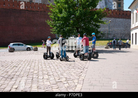 Eine Gruppe von Touristen, die Anweisungen für die Verwendung eines Segway Transporter, Krakau, Polen, Europa. Stockfoto