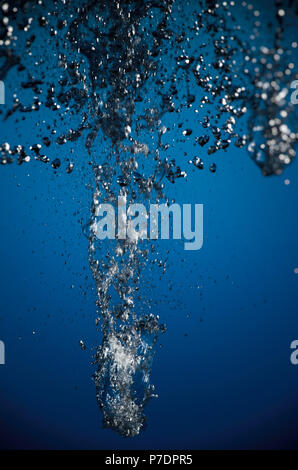 Abstrakte splash von Silber farbige Flüssigkeit auf blauem Hintergrund Stockfoto
