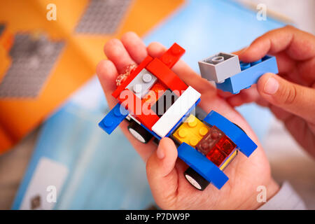 Tambow, Russische Föderation - Dezember 19, 2013 Kind Gebäude Lego Auto. Es gibt einige Lego Anleitung für den Hintergrund. Stockfoto