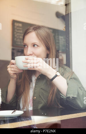Junge Frau mit Kaffee im café Stockfoto