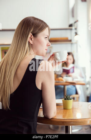 Junge Frau mit Kaffee im café Stockfoto