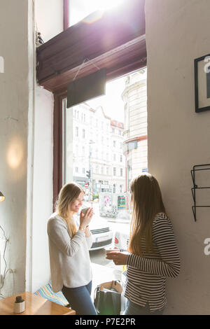 Junge Frauen über Kaffee im Cafe chatten Stockfoto