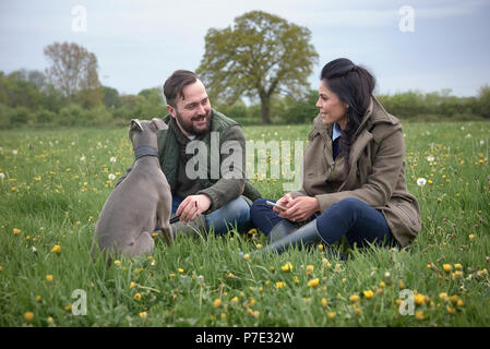 Frau und Mann im Feld mit Hund Stockfoto