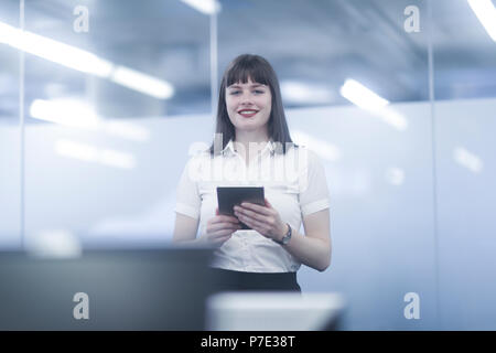 Geschäftsfrau mit digitalen Tablette, in die Kamera lächeln Stockfoto