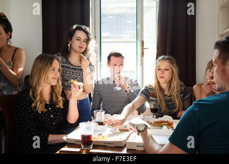 Gruppe von Freunden plaudern über Getränke und Pizza zu Hause Stockfoto