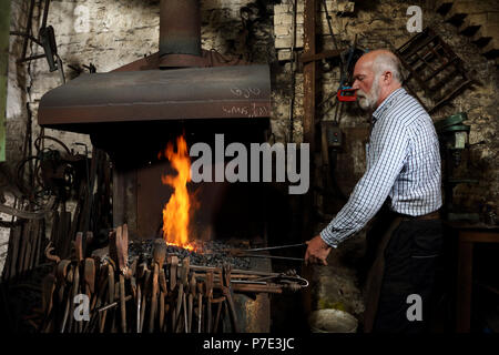 Schmied Heizung Metall im Feuer in der Schmiede shop Forge Stockfoto