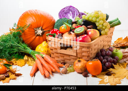 Sortiment an frischen und reifen im Herbst Gemüse und Früchte auf einem rustikalen Holztisch isoliert auf weißem Stockfoto