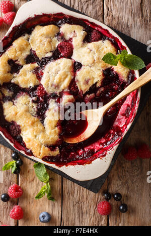 Berry Schuster mit Johannisbeeren, Himbeeren und Blaubeeren mit Minze in der Nähe auf den Tisch dekoriert. Senkrechte Draufsicht von oben Stockfoto