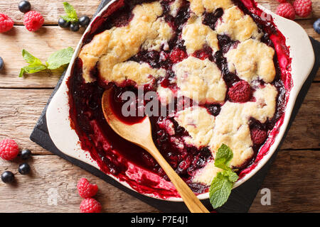 Berry Schuster mit Johannisbeeren, Himbeeren und Blaubeeren mit Minze in der Nähe auf den Tisch eingerichtet. Vertikal oben Ansicht von oben Stockfoto
