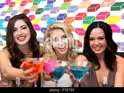 Spaß Frauen Freunde holding Cocktails mit bunten geometrischen Muster Stockfoto