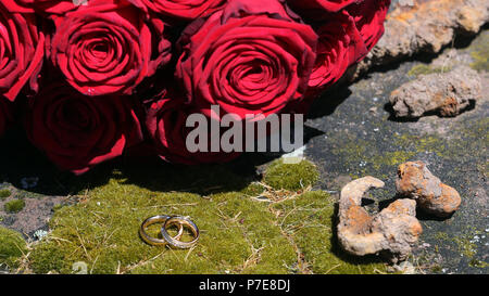 Goldene Hochzeit Ringe stilvoll vor der Brautstrauß angeordnet Stockfoto