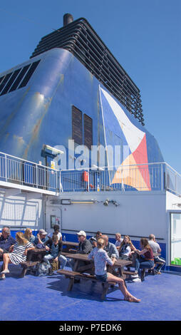 Menschen sonnen sich auf offenen hinteren Deck von P&O Fähre Dover verlassen mit im Hintergrund Trichter. Stockfoto