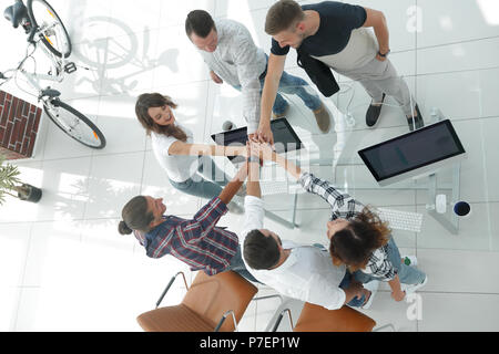 Kreatives Team mit gefalteten Händen zusammen. Stockfoto