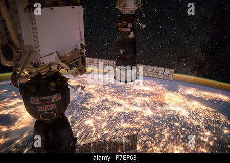 Erdbeobachtung genommen während einer Nacht passieren die Expedition 49 Crew an Bord der Internationalen Raumstation (ISS). Angedockte Sojus und Progress sichtbar. Stockfoto