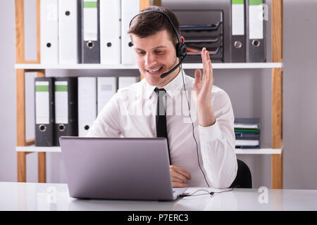 Junge Unternehmer können Sie über Kopfhörer Während der Arbeit am Laptop am Arbeitsplatz Stockfoto