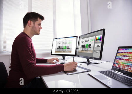 Seitenansicht eines jungen männlichen Designer auf Grafik Tablett während der Arbeit am Computer Stockfoto