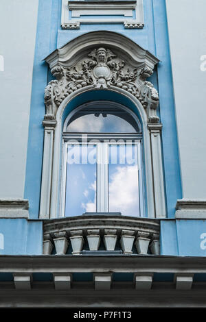 Ein Fenster und Balkon mit bas-relief auf der Fassade. Dekorative Fensterrahmen. Stockfoto