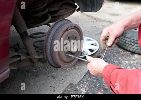 Ein KFZ Mechaniker arbeiten UND ZUR FESTSETZUNG Autos in North West London, Großbritannien Stockfoto