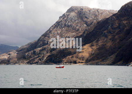 Ein Boot unter Berge im Loch Nevis vor der Küste der Halbinsel Knoydart, Northwest Highlands, Schottland, Großbritannien. Stockfoto