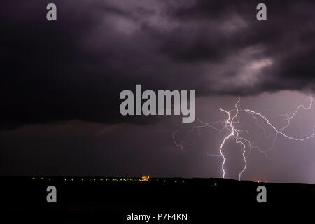 Eine mezocyclone Gewitter mit dunklen Wolken, die über einer kleinen Stadt im Tornado Alley, Oklahoma bei Nacht Stockfoto